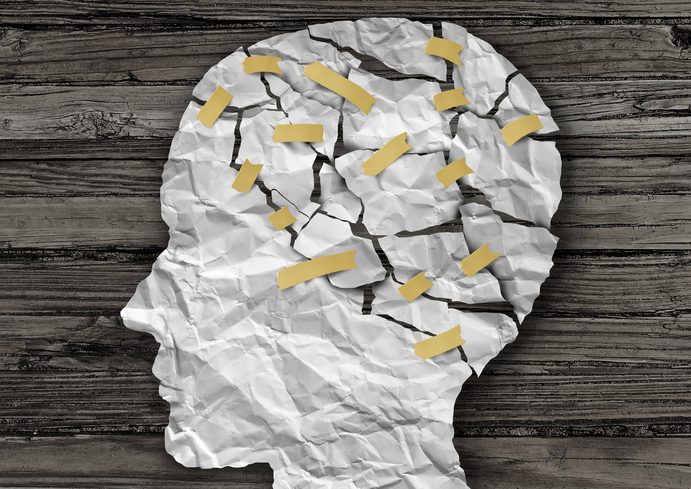 illustration d'un profil latéral humain en papier avec une zone du cerveau déchirée et recollée