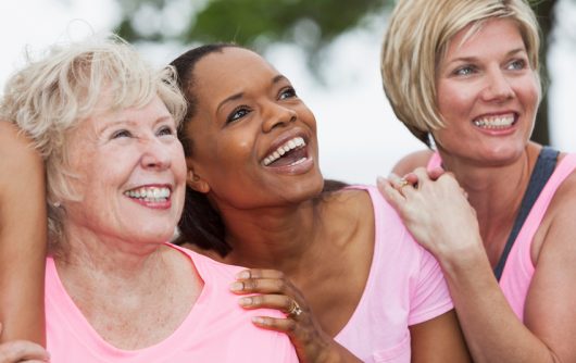 group of women wearing pink and embracing