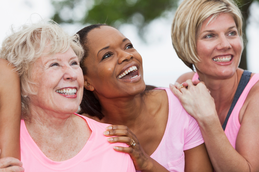 group of women wearing pink and embracing