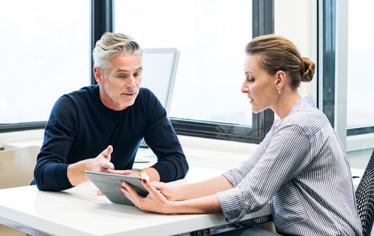 Adult man and woman looking at tablet