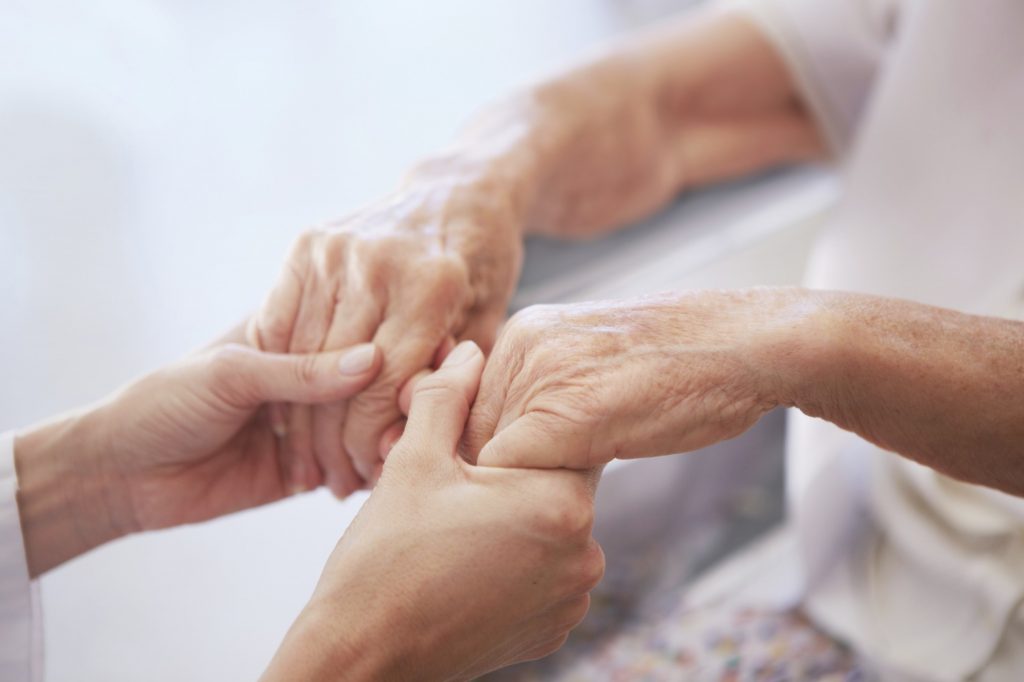 young hands holding senior hands