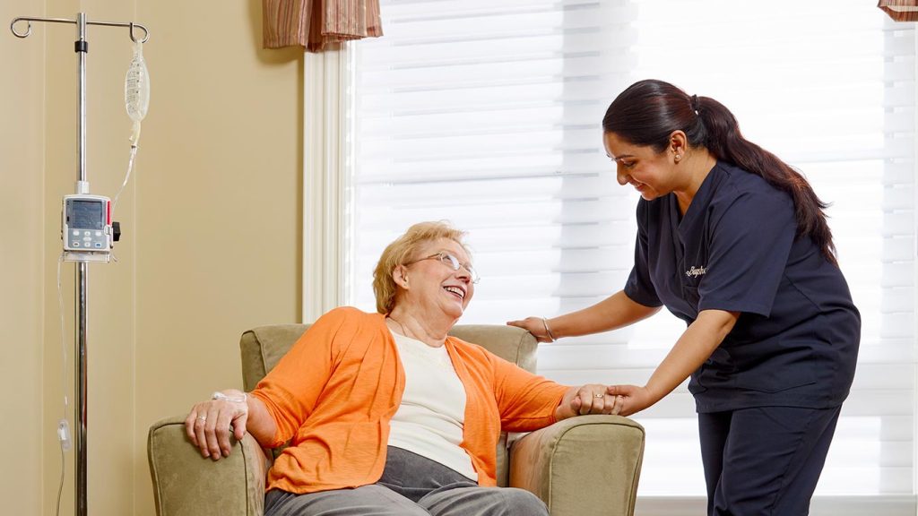 Nurse holding senior woman's hand