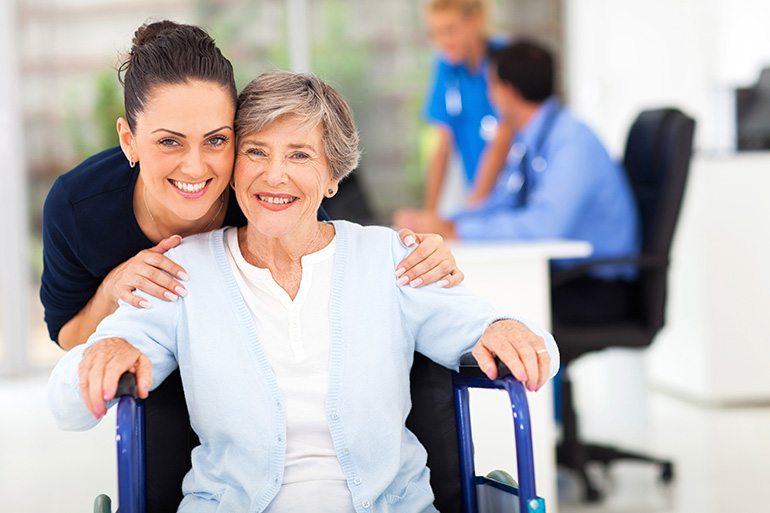 senior woman in wheelchair with caregiver