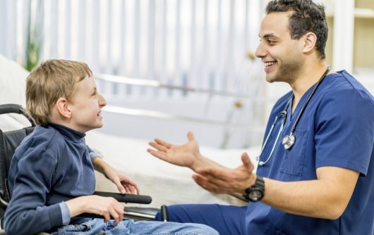 infirmière parlant à un enfant en fauteuil roulant