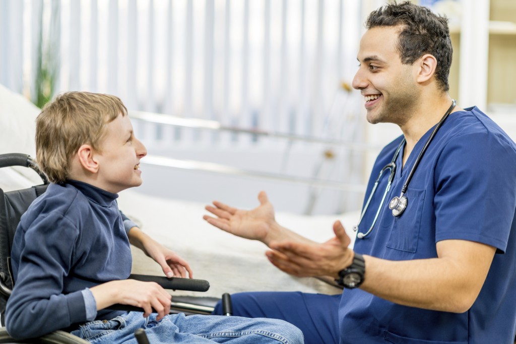 infirmière parlant à un enfant en fauteuil roulant