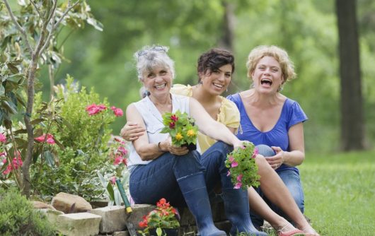 Senior women with young woman gardening