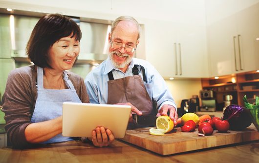 couple de personnes âgées lisant la recette de la tablette