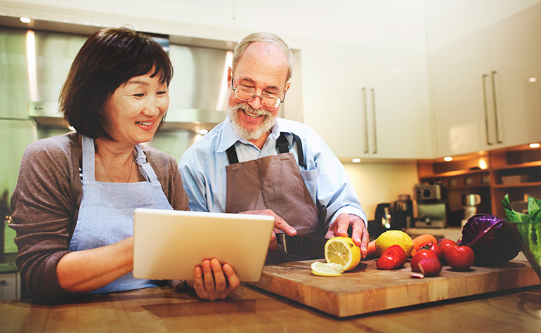 couple de personnes âgées lisant la recette de la tablette