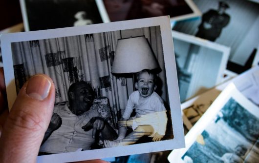 main tenant une photo en noir et blanc d'un homme adulte et d'un bébé