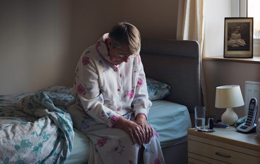 Senior woman sitting on edge of bed