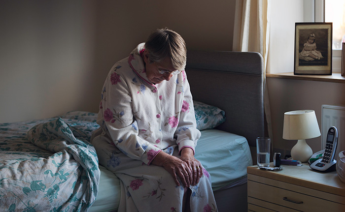 Senior woman sitting on edge of bed