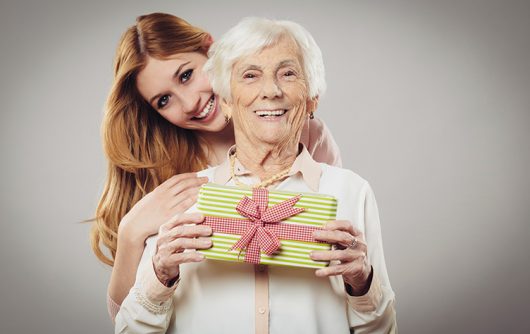 Senior woman with daughter holding present