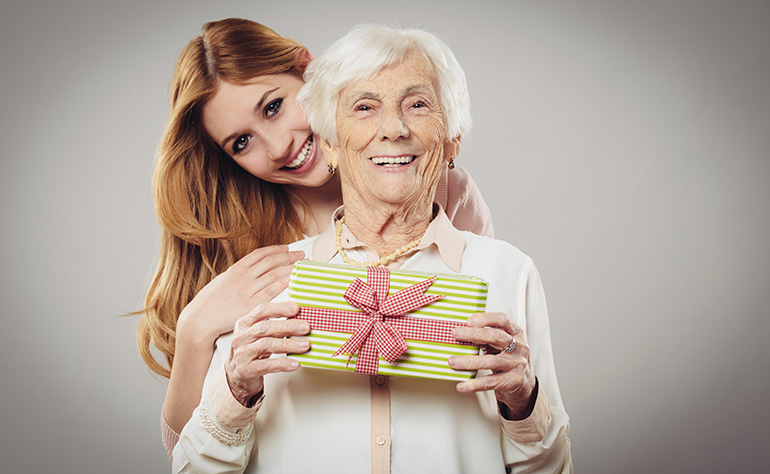 Senior woman with daughter holding present