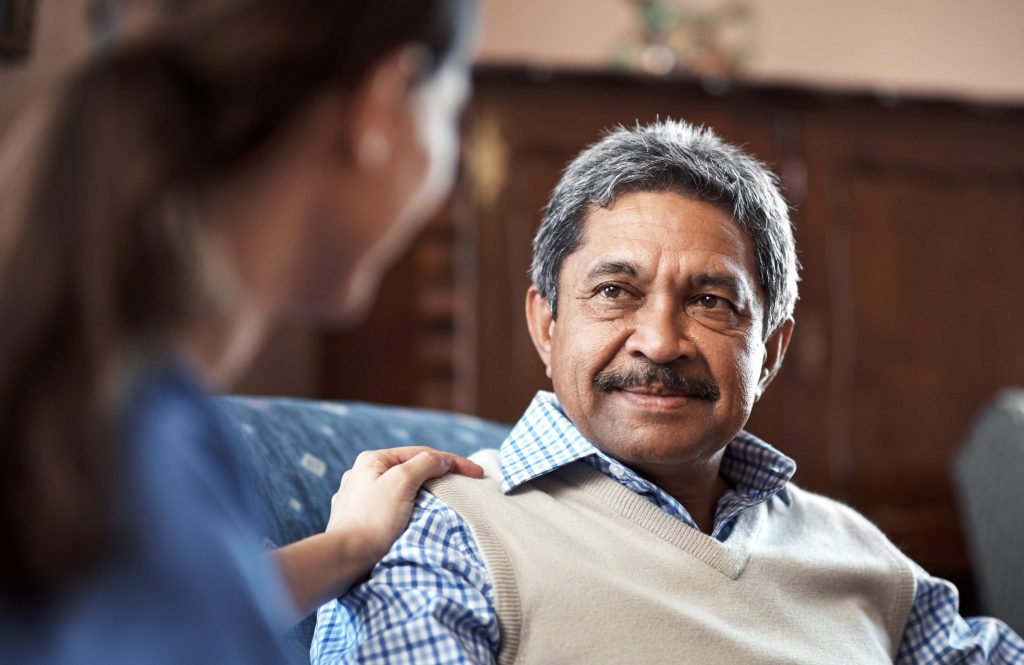 A caregiver sat with a senior man