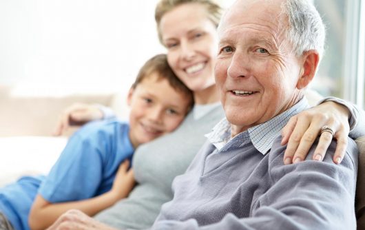 homme senior souriant à la caméra avec sa fille et son petit-fils