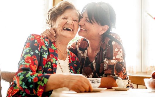 femme âgée et femme adulte riant et s'embrassant