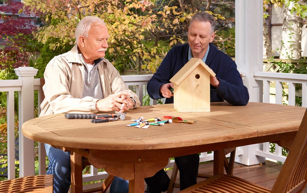 Homme âgé et fils construisant une maison d'oiseau