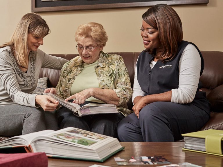 Caregiver and senior woman looking at photo album