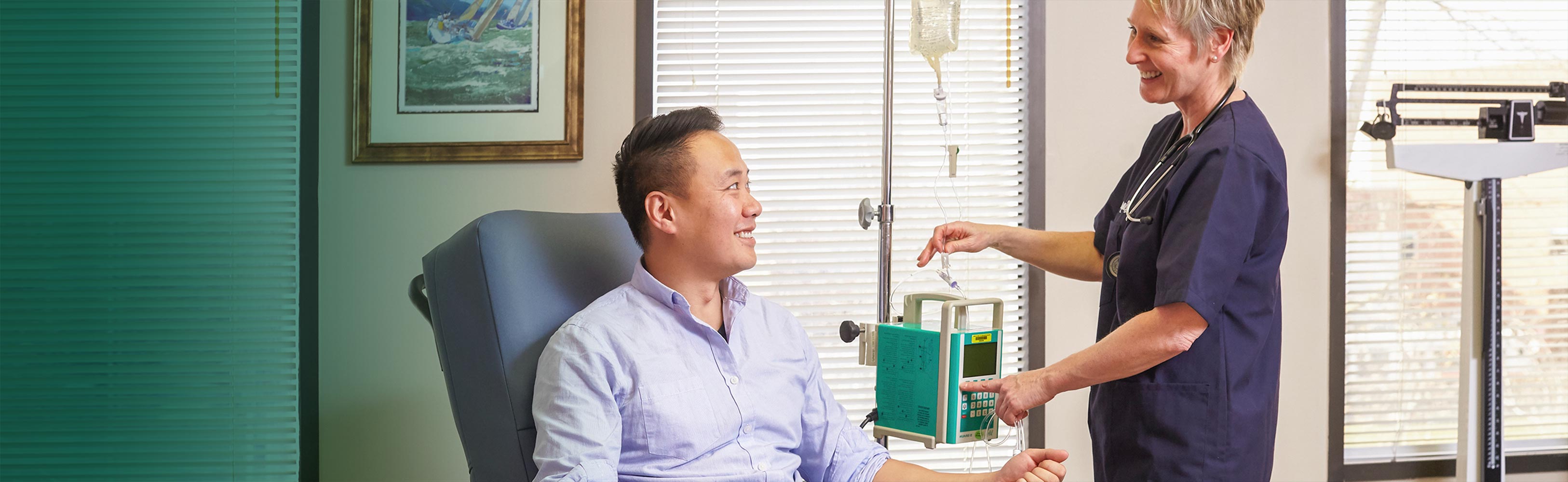 Nurse checking up on a young man. They both are smiling at each other.