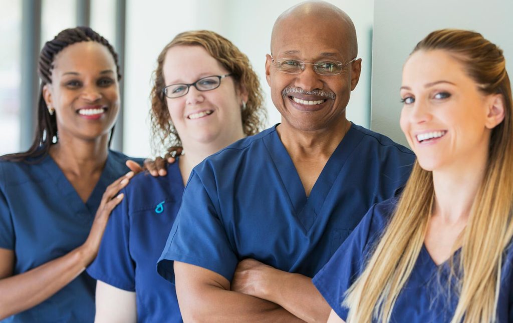 Caregivers stood together smiling for a photograph.