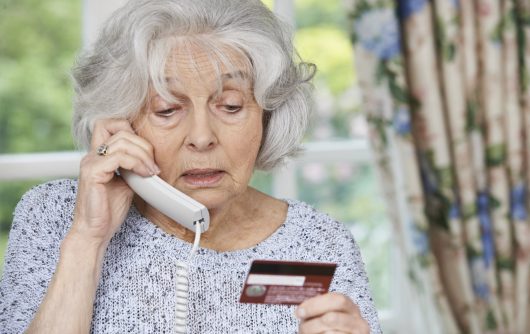 Senior woman on phone holding credit card