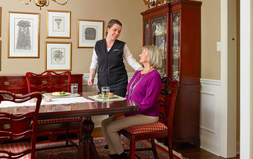 soignant et femme âgée au dîner