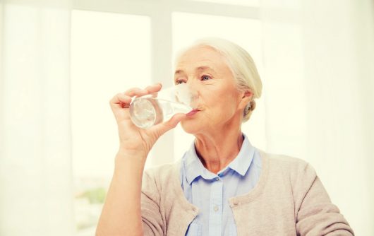 Senior woman drinking glass of water