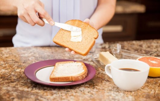 personne beurrant des toasts