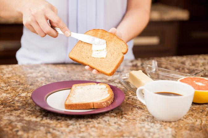 personne beurrant des toasts