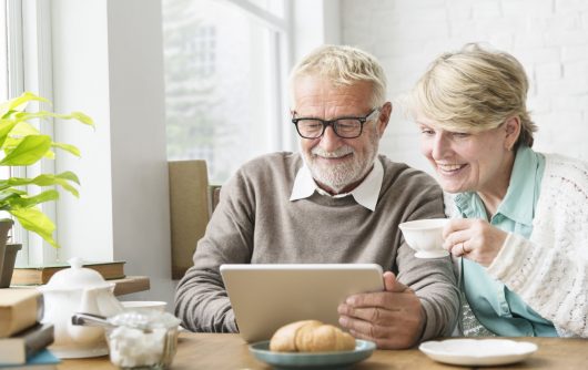 Senior couple smiling at tablet