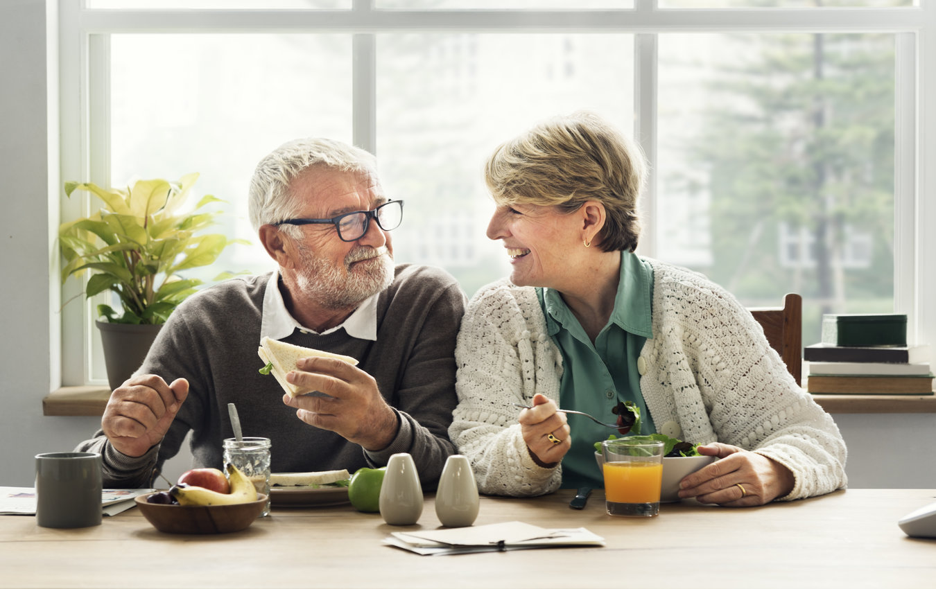 Senior couple eating lunch, smiling