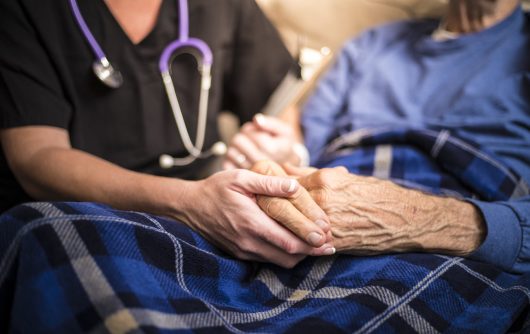 Nurse holding senior's hands