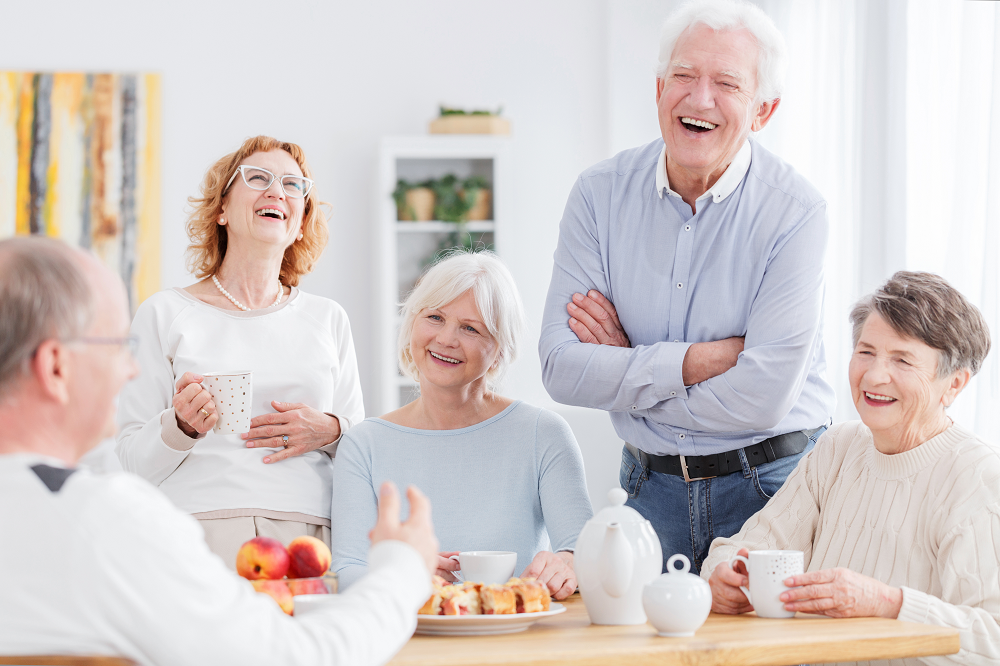 groupe de personnes âgées mangeant et riant