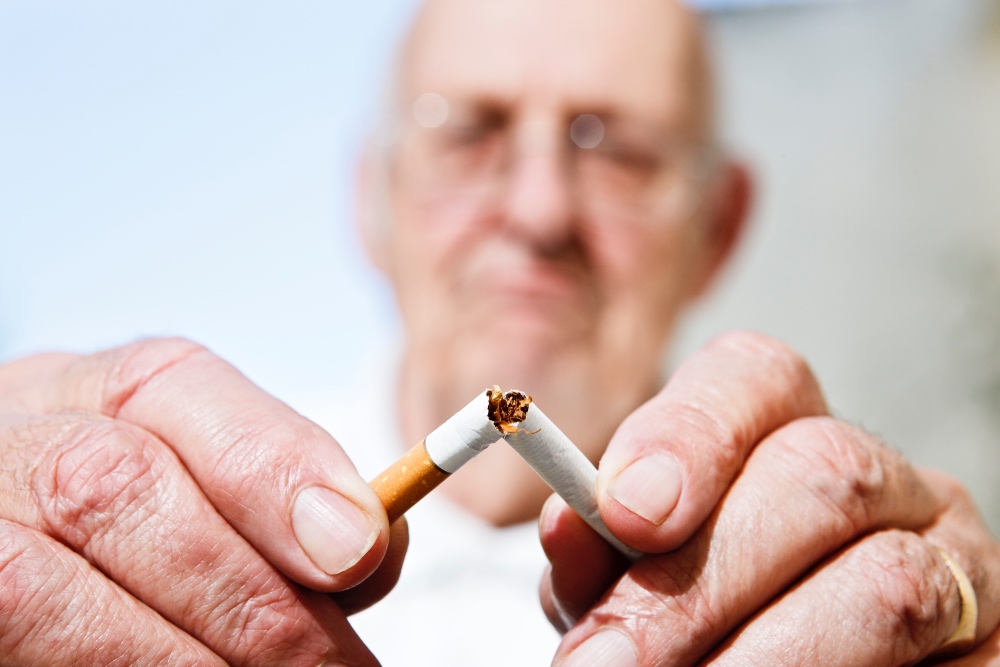 Senior man snapping cigarette in half