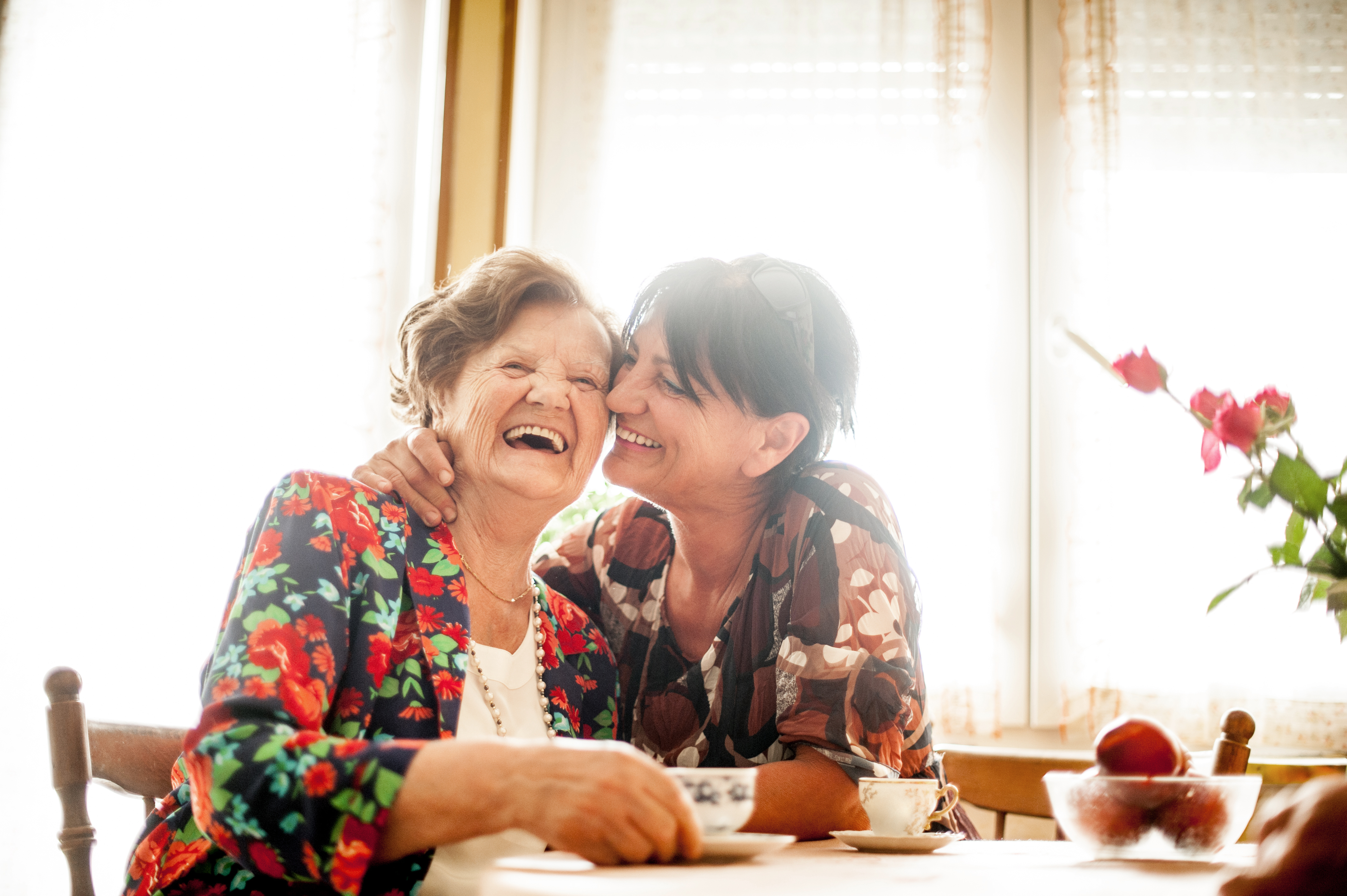 senior woman and daughter hugging at home