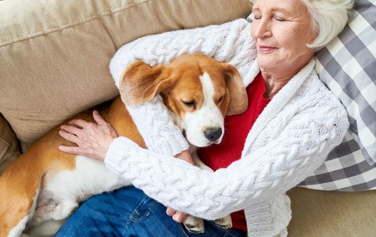 senior woman napping with dog