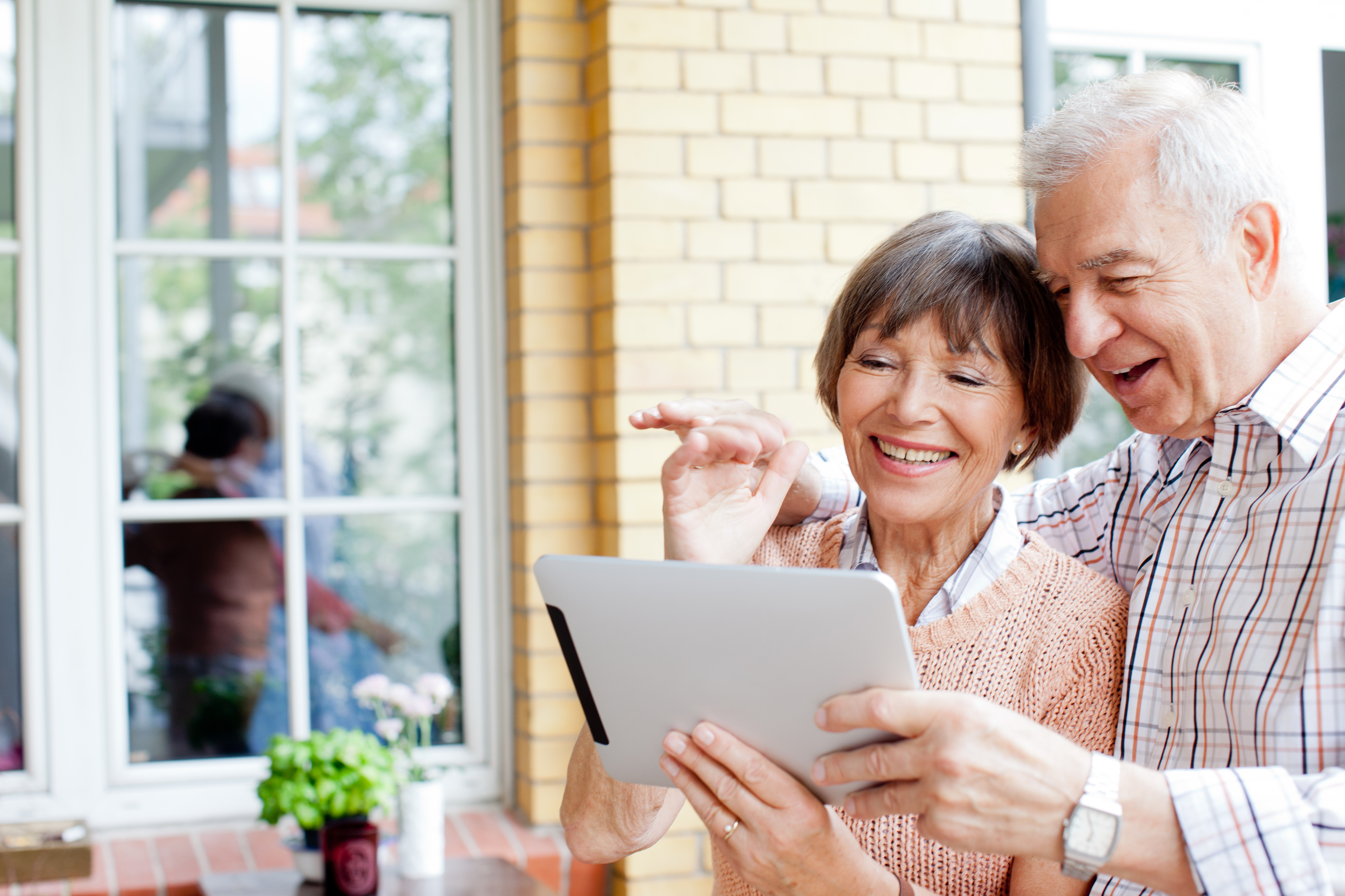 Senior couple smiling at tablet