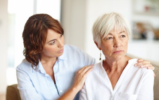 Daughter embracing mother in pain