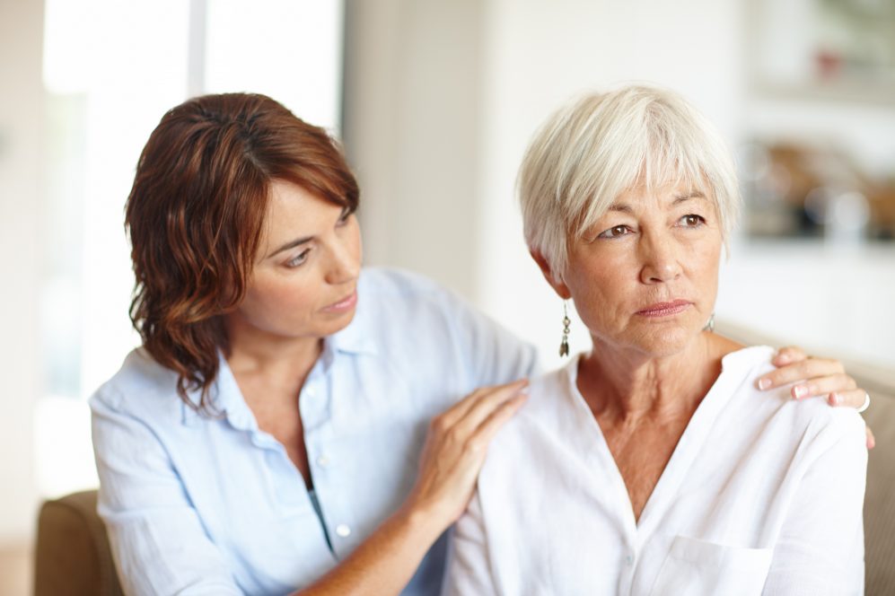 Daughter embracing mother in pain