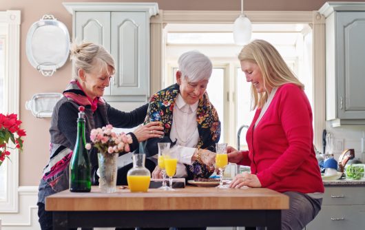 senior mother and daughters having drinks