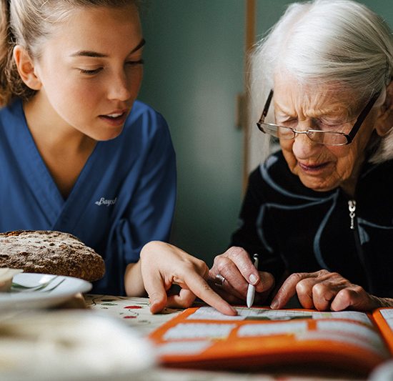 Caregiver assisting a senior with Sudoku