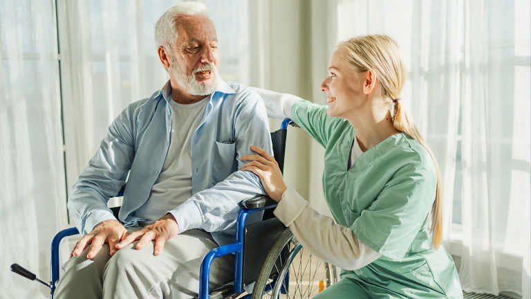 Nurse taking care of an elderly man in a wheel chair