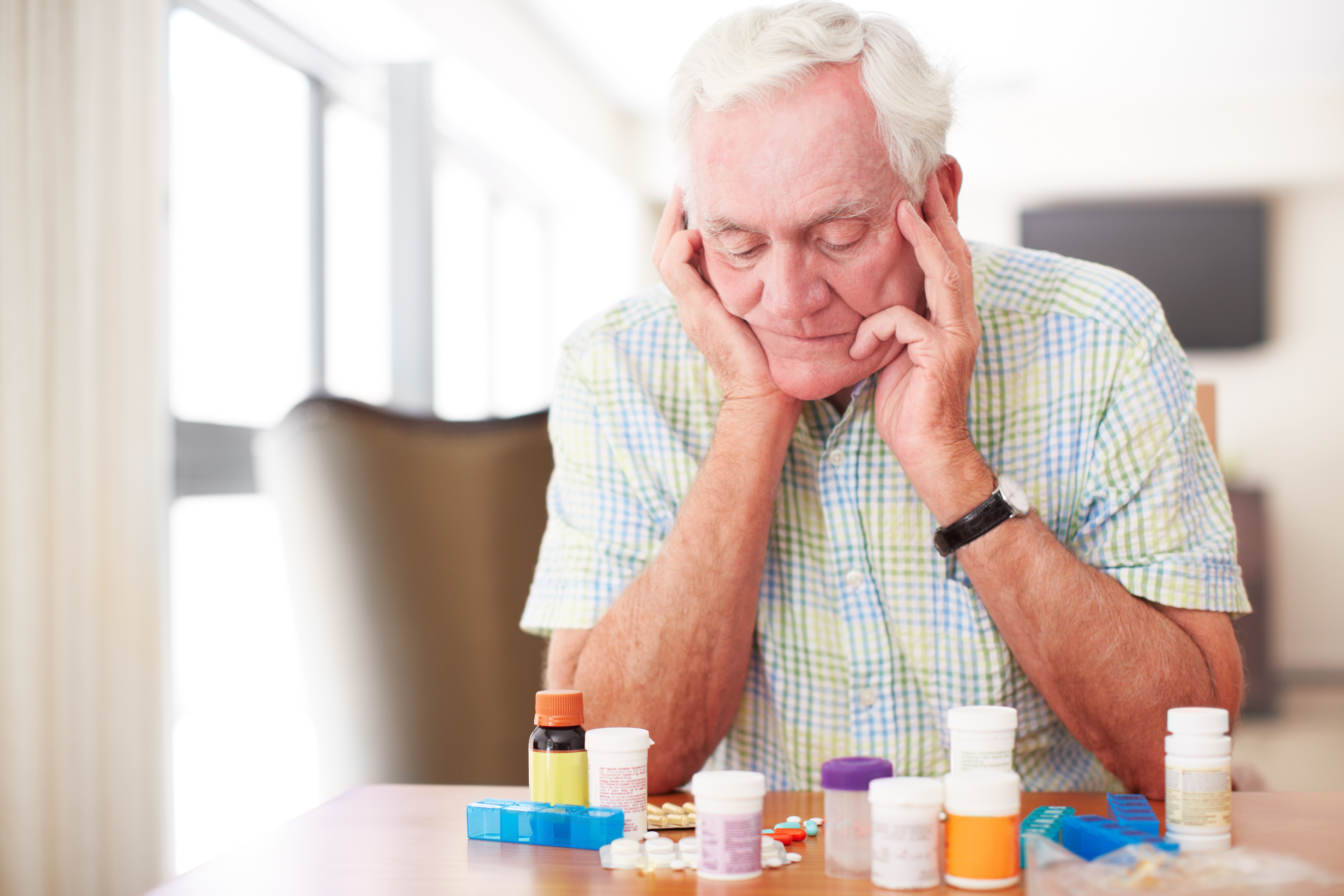 Homme supérieur regardant beaucoup de médicaments