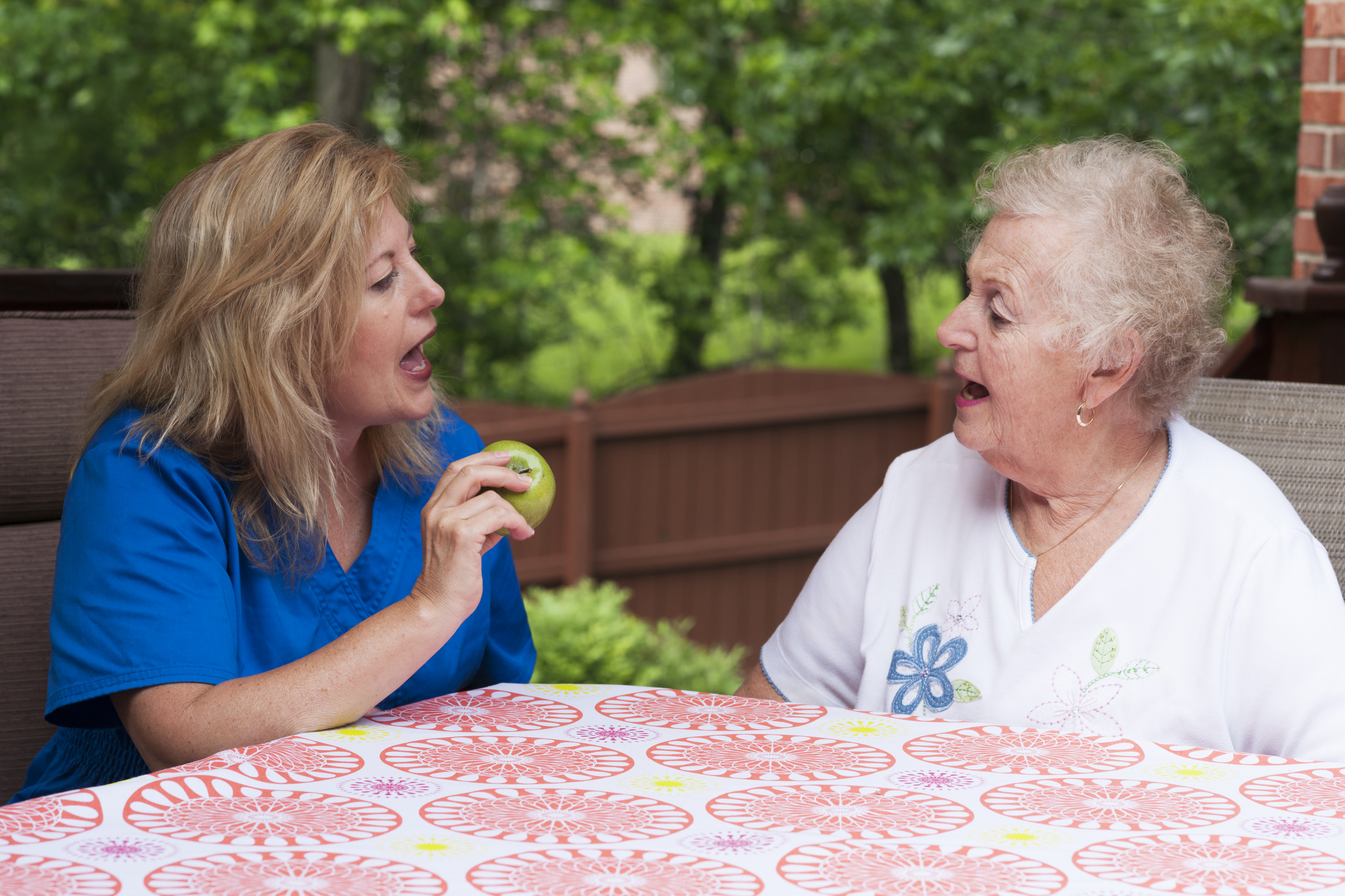 Speech therapist teaching senior woman patient