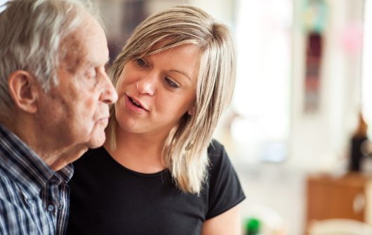 Young woman talking to senior man