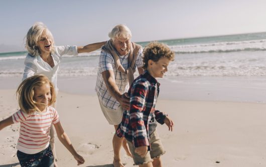 Grands-parents et petits-enfants jouant sur la plage