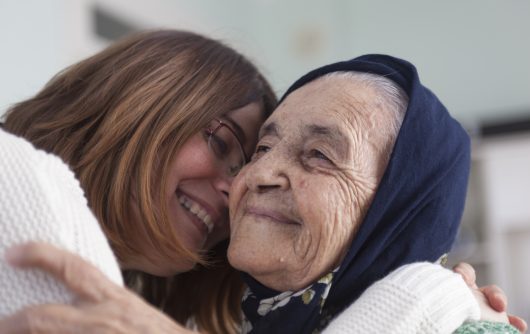 young woman hugging senior woman