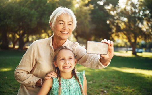 femme âgée et petit-enfant prenant selfie