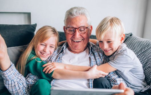 enfants étreignant grand-père sur un canapé