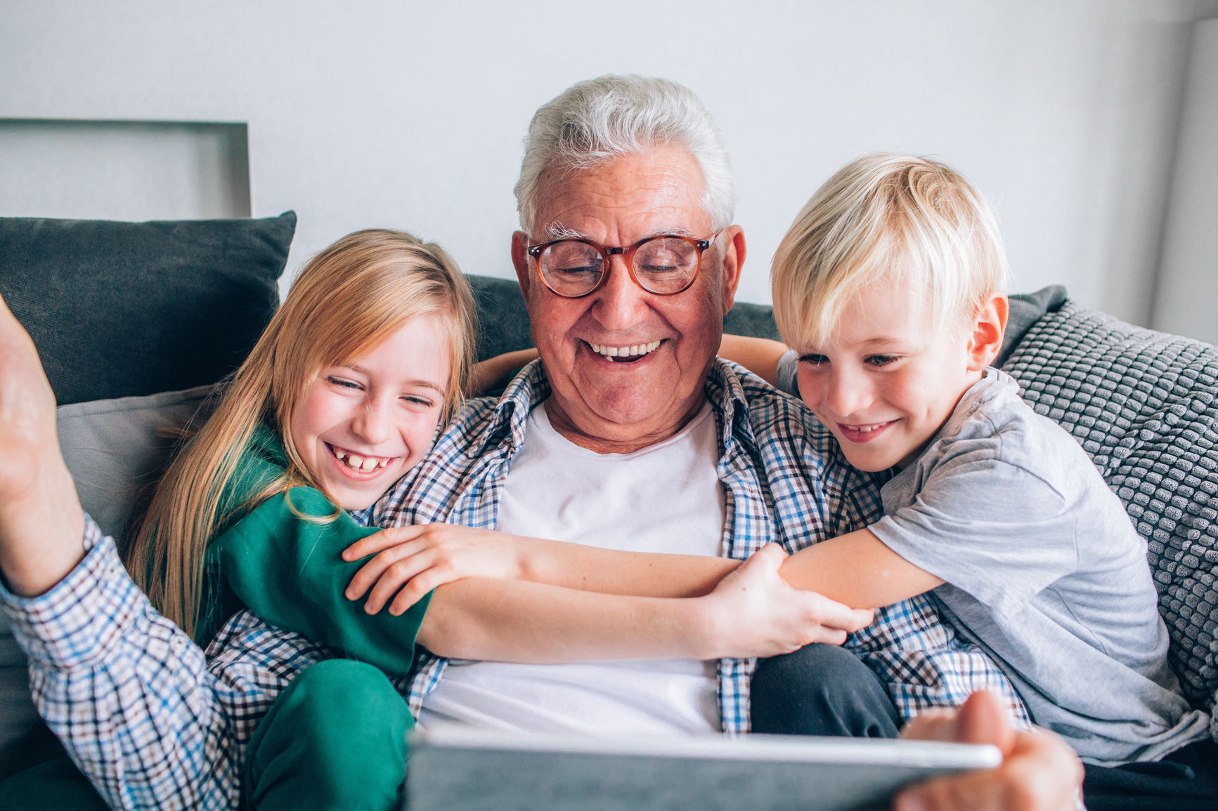 enfants étreignant grand-père sur un canapé